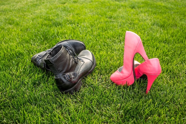 Sapatos de um homem e uma mulher na grama verde conceito de férias de verão