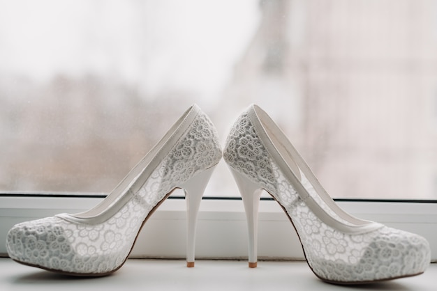 Sapatos elegantes de casamento branco da noiva com renda