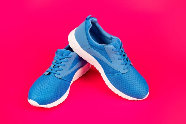 Sapatos em fundo rosa. loja de sapatos. conceito de compras. calçado para treino. calçado atlético para corrida. par de calçados esportivos confortáveis. tênis azuis esportivos.