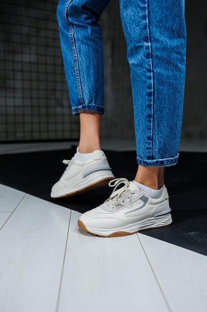 Sapatos esportivos para mulheres Pernas femininas finas em jeans e tênis casuais elegantes brancos Sapatos de verão confortáveis para mulheres Moda feminina casual
