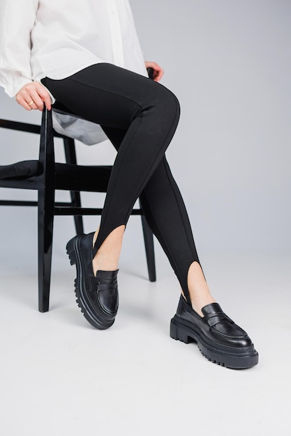 Sapatos femininos Closeup de pernas femininas em leggings pretas e mocassins de couro preto Nova coleção primavera-verão de sapatos femininos de couro