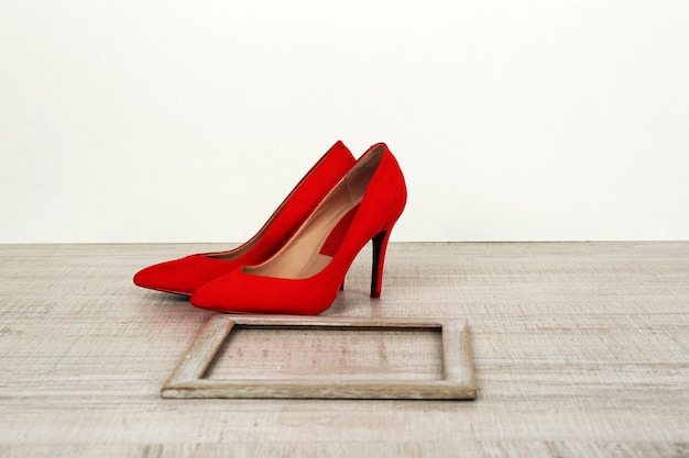 Sapatos femininos vermelhos com moldura no chão
