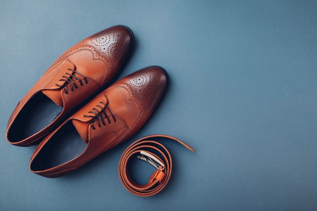 Sapatos masculinos Oxford brogues com acessórios. Moda masculina. Calçado de couro marrom clássico com cinto. Espaço