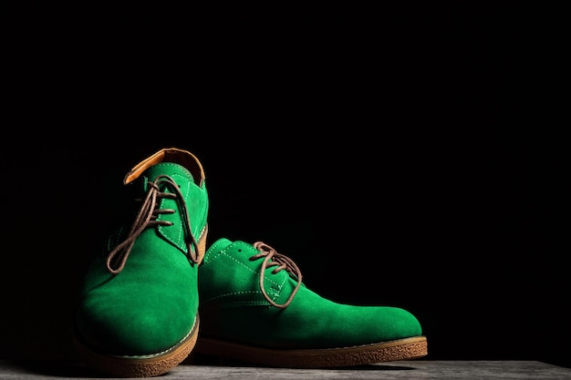 Sapatos verdes de concerto com atacadores em um fundo preto com espaço de cópia