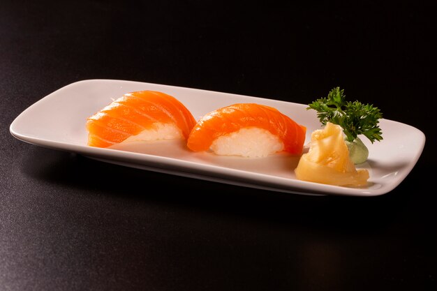 Saquê - nigiri sushi com salmão cru em fundo preto