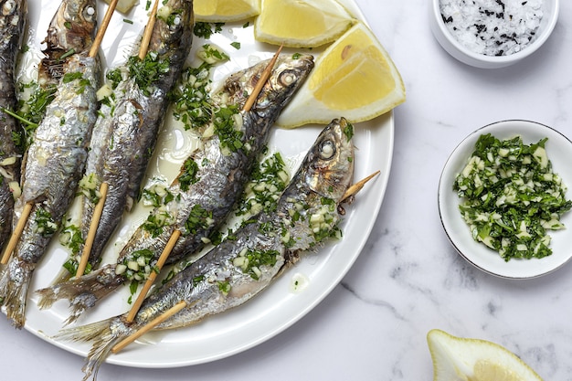 Sardinas caseras a la parrilla con ajo, aceite de oliva, perejil fresco y limón.Concepto de comida saludable