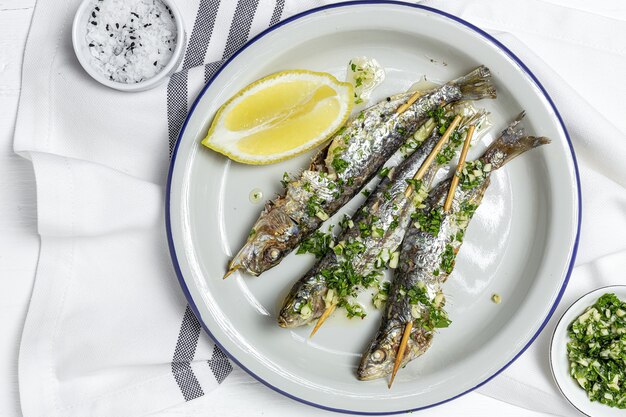 Sardinas caseras a la parrilla con ajo, aceite de oliva, perejil fresco y limón.Concepto de comida saludable