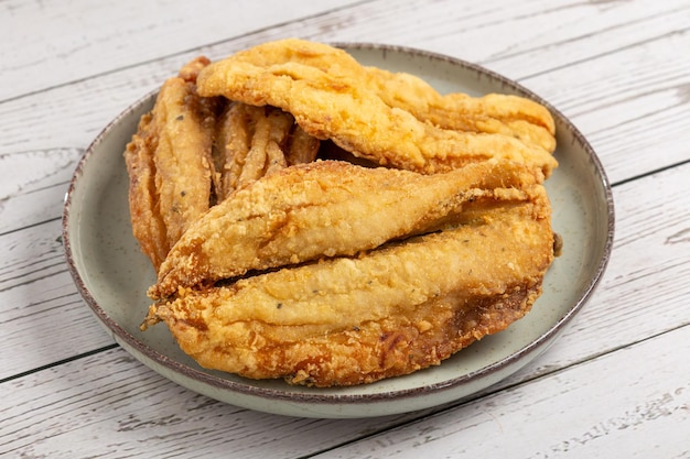 Sardinas fritas en el plato sobre la mesa.