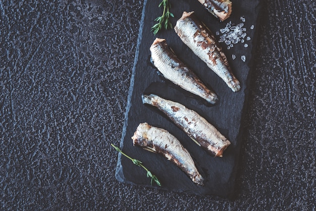 Sardinas en el tablero de piedra negra