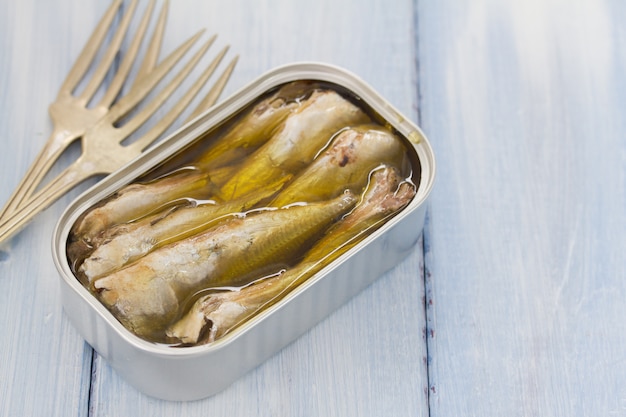 Sardinen im Eisenkasten auf blauem hölzernem