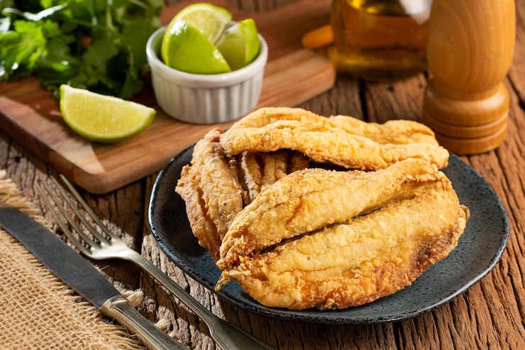 Foto sardinhas fritas no prato sobre a mesa.