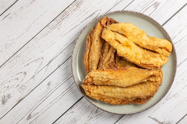 Sardinhas fritas no prato sobre a mesa.