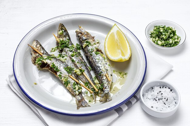 Sardinhas grelhadas caseiras com alho, azeite, salsa fresca e limão. Conceito de comida saudável