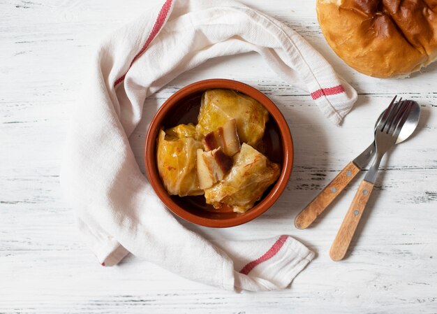 Sarma - plato tradicional de la cocina balcánica. Rollitos de col con carne y arroz. Cocina balcánica. Cocina serbia. Fondo claro de madera. Vista superior. Espacio para texto