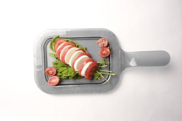 Foto una sartén de comida con verduras y un cuchillo con un fondo blanco