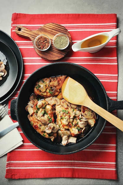 Sartén con delicioso pollo marsala en mesa