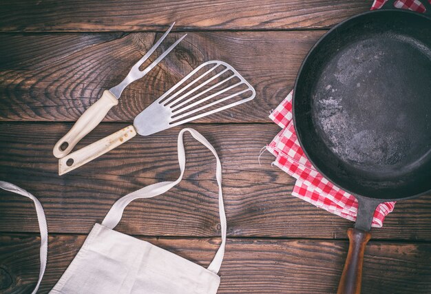 Sartén de hierro fundido negro vacío y utensilios de cocina