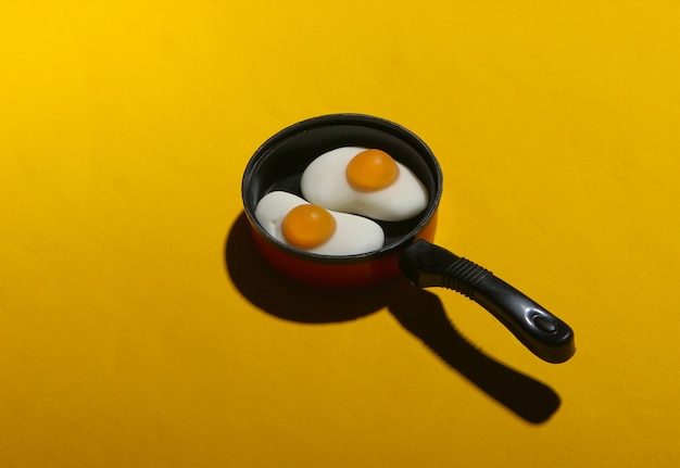 Sartén de juguete en miniatura con huevos fritos en amarillo