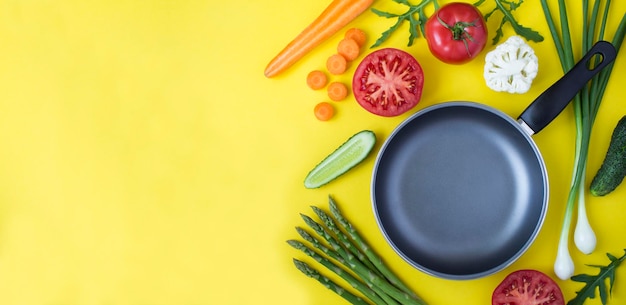 Sartén de metal vacía y verduras en el fondo amarillo Espacio de copia Vista superior