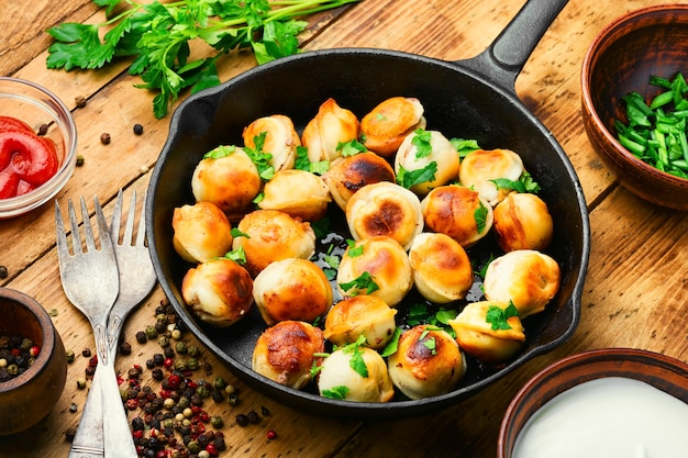 Sartén con sabroso pelmeni asado.