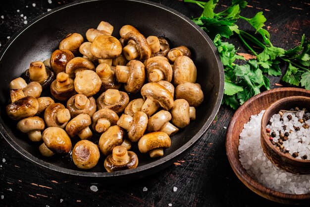 sartén con setas pequeñas fritas con perejil