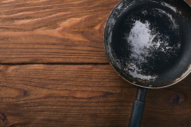 Sartén Sobre un fondo negro de madera Vista superior Espacio libre para su texto