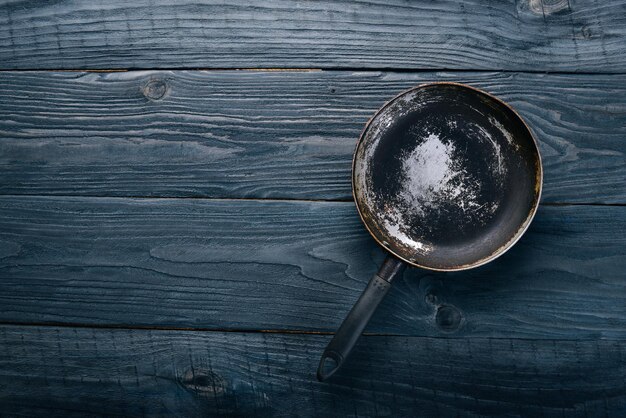 Sartén Sobre un fondo negro de madera Vista superior Espacio libre para su texto