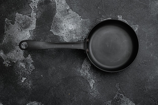 Sartén vacía con espacio para copiar texto o comida con espacio para copiar texto o comida, vista superior plana, sobre fondo de mesa de piedra oscura negra