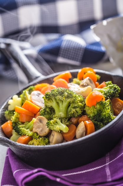 Sartén vegana. Comida vegetariana: brócoli, zanahoria, champiñones, sal, pimienta, mantequilla.