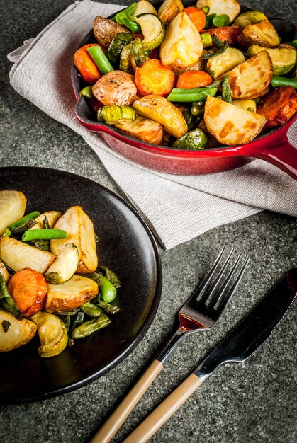 Sartén con vegetales fritos de otoño (calabacín, papas, zanahorias, frijoles)