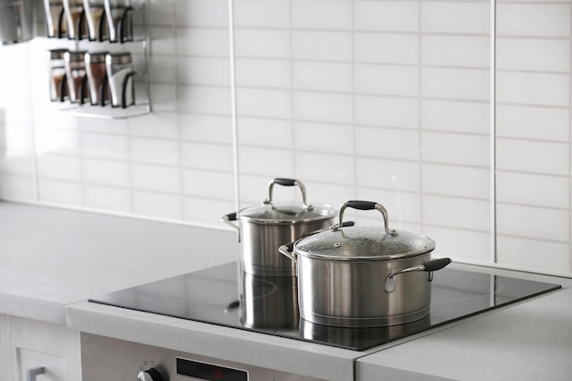 Foto sartenes de metal en la estufa de la cocina moderna