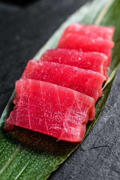 Foto sashimi de atún sobre una tabla de piedra. vista superior. de cerca