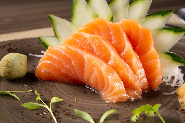 Sashimi de salmão com decoração verde. Comida japonesa.