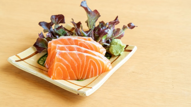 Sashimi de salmão fresco em uma mesa de madeira.