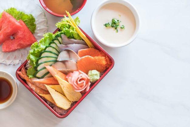 Sashimi fresco crudo con arroz en caja bento