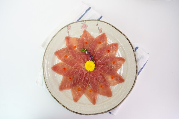 Sashimi de maguro crudo en rodajas en un plato de cerámica