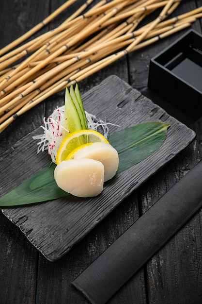 Sashimi en un plato sobre una mesa oscura cocina japonesa