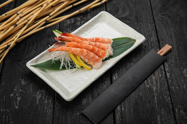 Sashimi en un plato sobre una mesa oscura cocina japonesa