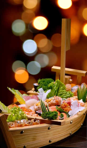 Sashimi de sushi en un barco de madera sobre una mesa de madera marrón. Con melón, gambas, gambas, jengibre