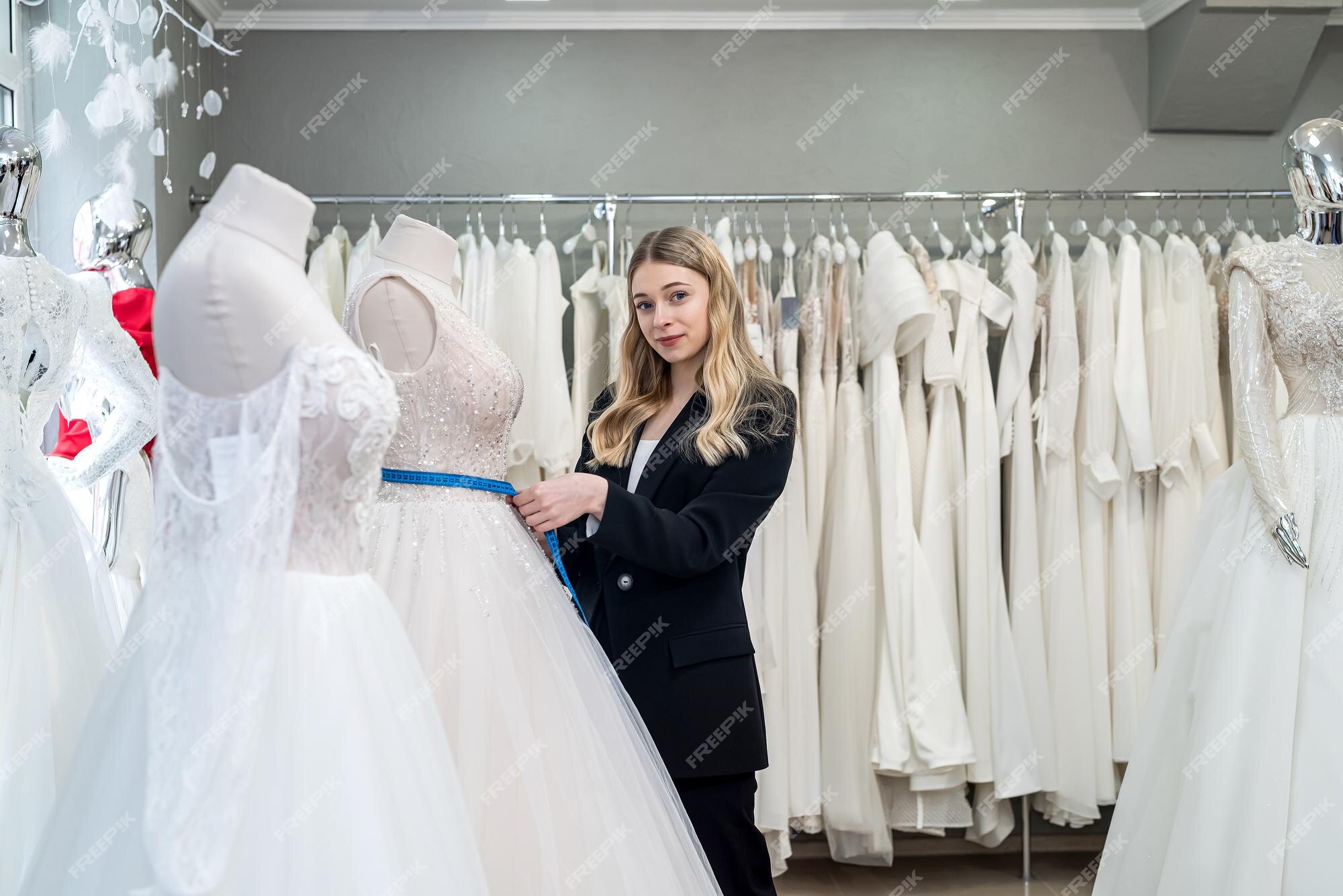 Sastre femenino midiendo elegante vestido de novia en maniquí usando cinta métrica | Foto Premium Sastre femenino midiendo elegante vestido de novia en maniquí usando cinta métrica | Foto Premium