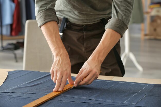 Sastre joven que trabaja con la materia textil en atelier