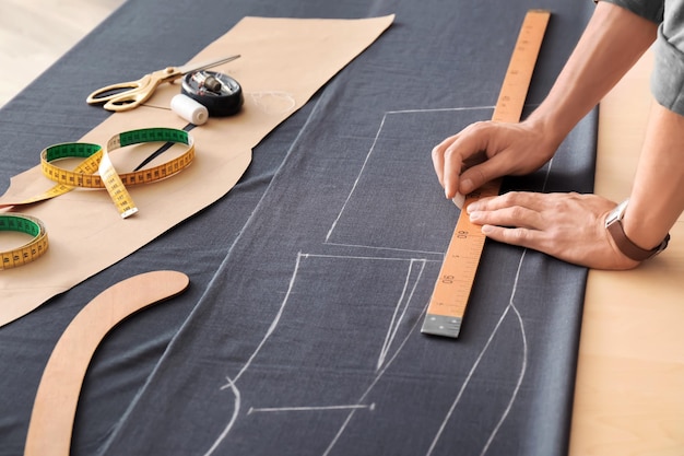 Sastre joven que trabaja con la materia textil en atelier