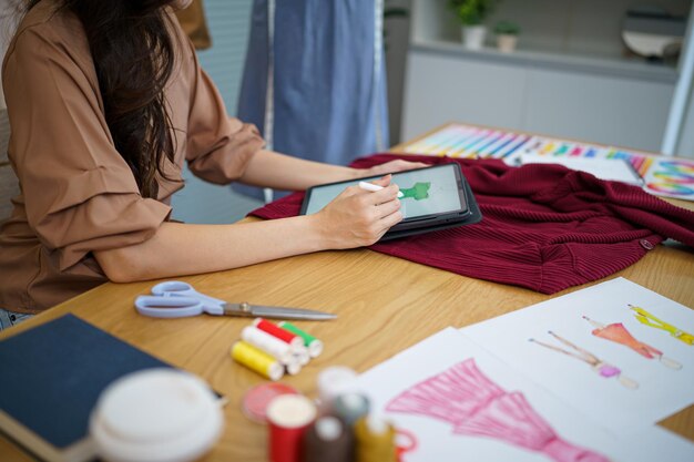 Foto sastre mujer trabajando en sastrería elegante diseñadora de moda sastre en taller estudio diseñando nueva colección confección y colección creativexafashion