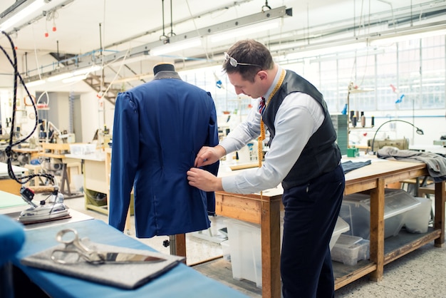 Sastre trabajando en chaqueta en taller