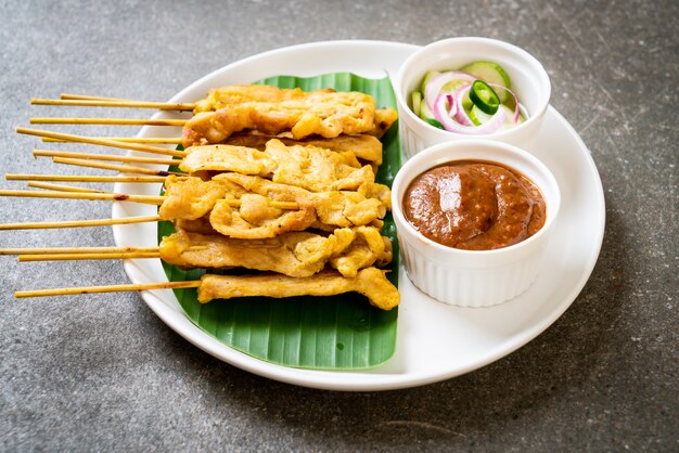 Satay de cerdo: cerdo a la parrilla servido con salsa de maní o salsa agridulce