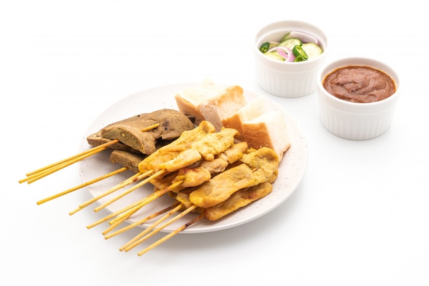 Satay de cerdo con salsa de maní y encurtidos