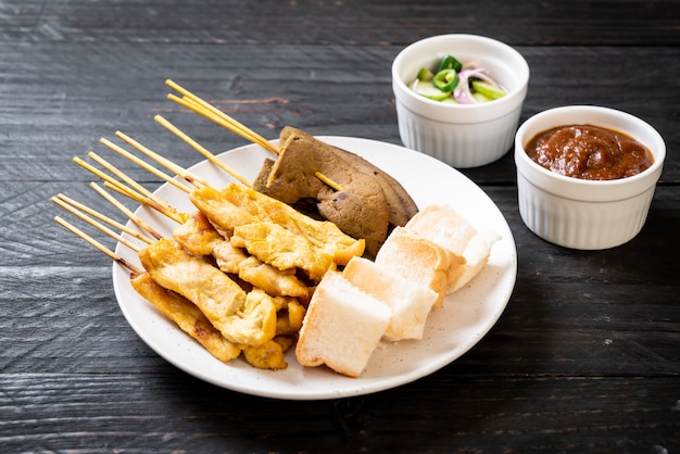 Satay de cerdo con salsa de maní y encurtidos