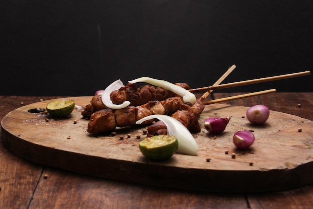 Foto satay servido en una tabla de cortar.