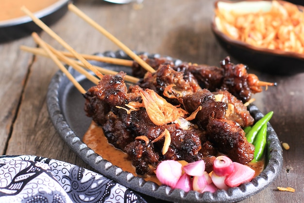 Sate Kambing es cordero satay, carne de cordero asada comida tradicional de Indonesia servida con salsa de maní para el menú Idul Adha