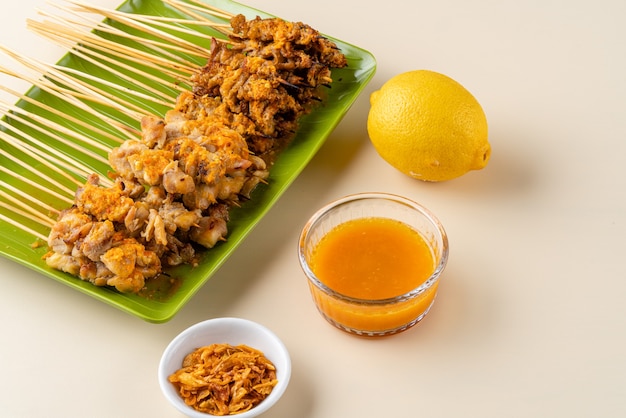 Sate taichan ou Taichan satay com pele de frango grelhado servido com molho de pimenta